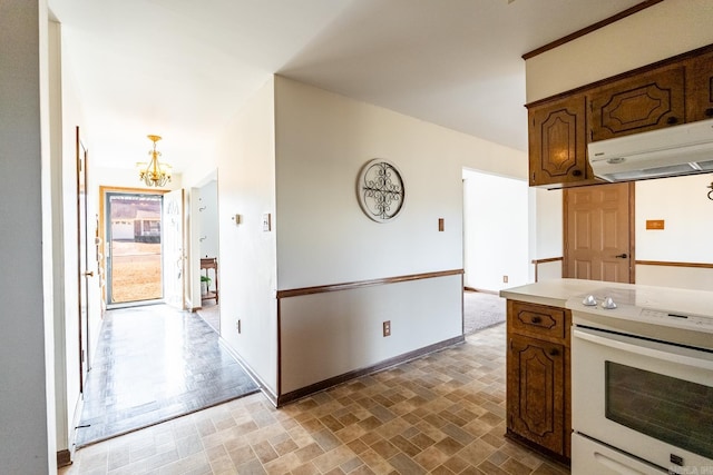 kitchen featuring ventilation hood, white electric range oven, and a chandelier