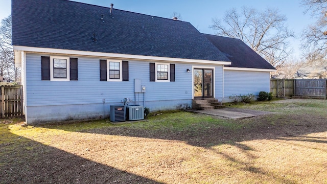 rear view of house featuring a yard, central air condition unit, and a patio area