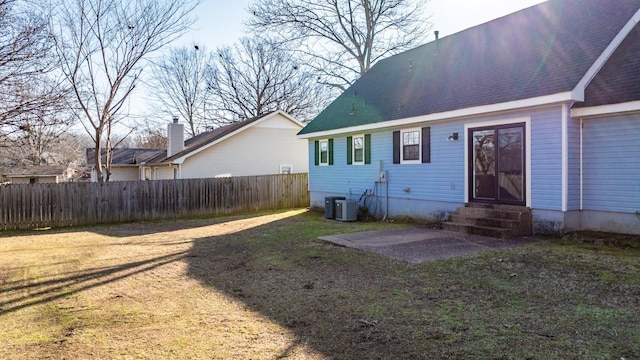 rear view of house featuring a yard, cooling unit, and a patio area