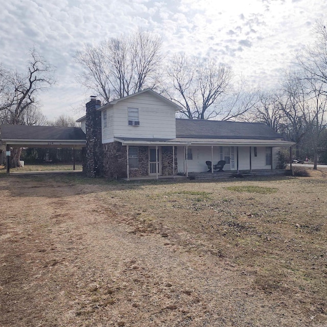 rear view of house with a porch, a yard, and a carport