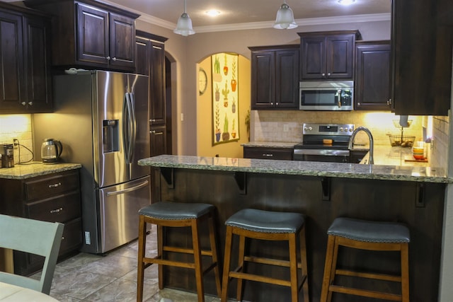 kitchen featuring light stone counters, dark brown cabinetry, stainless steel appliances, and decorative backsplash