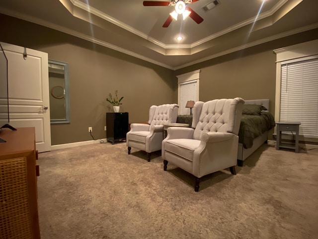 carpeted cinema room with crown molding, a tray ceiling, and ceiling fan
