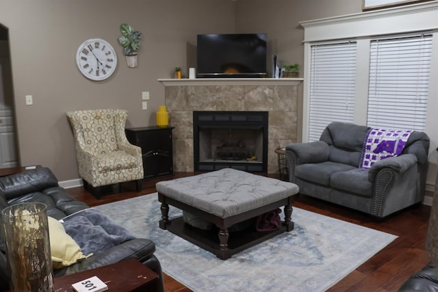 living room with dark hardwood / wood-style flooring and a tile fireplace