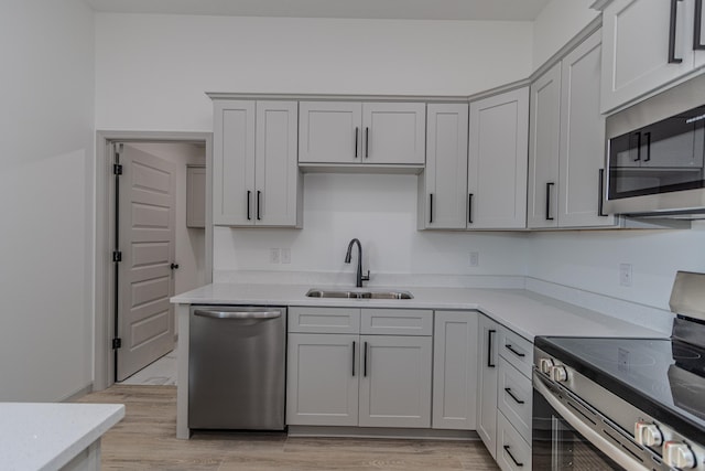 kitchen featuring sink, stainless steel appliances, and light hardwood / wood-style floors