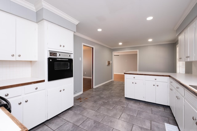 kitchen featuring white cabinetry, crown molding, kitchen peninsula, and black oven