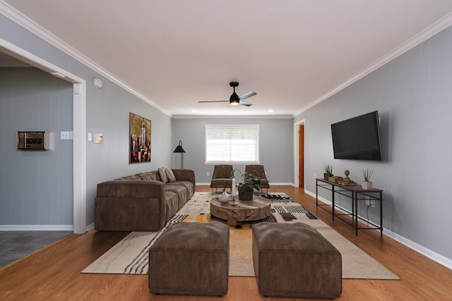 living room featuring wood-type flooring, ornamental molding, and ceiling fan