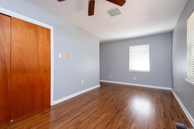 unfurnished room featuring dark wood-type flooring and ceiling fan