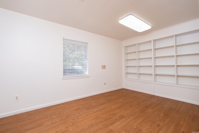 empty room featuring hardwood / wood-style flooring and built in features