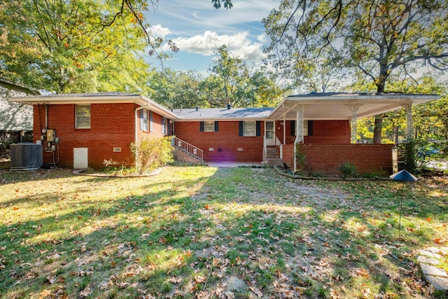 rear view of property featuring cooling unit, a yard, and a carport