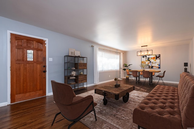 living room featuring an inviting chandelier and dark hardwood / wood-style floors