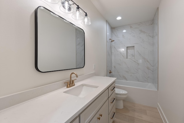 full bathroom featuring tiled shower / bath, hardwood / wood-style floors, vanity, and toilet