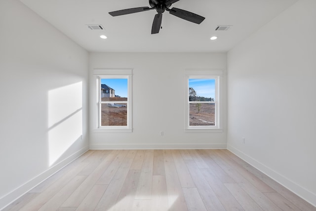 empty room with ceiling fan and light hardwood / wood-style floors