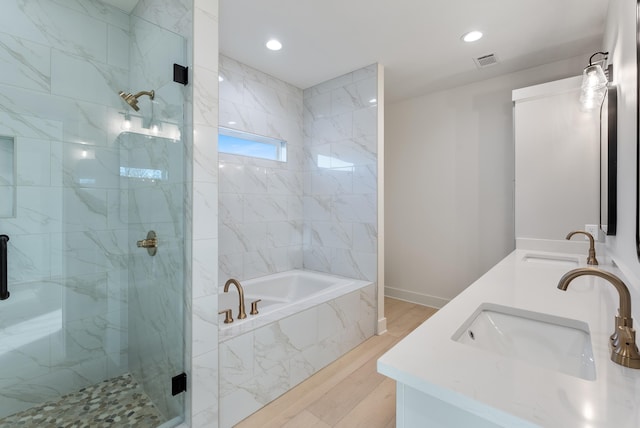 bathroom featuring vanity, hardwood / wood-style floors, and independent shower and bath