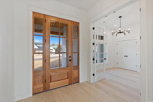 entrance foyer with a notable chandelier and light hardwood / wood-style flooring