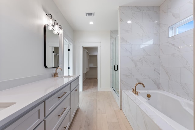 bathroom featuring vanity, separate shower and tub, and wood-type flooring