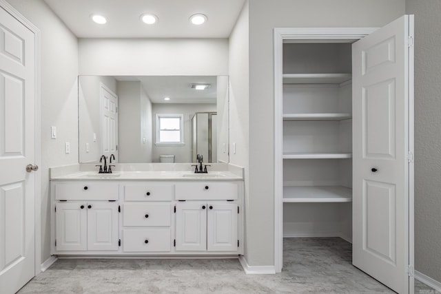 bathroom with a shower with door and vanity