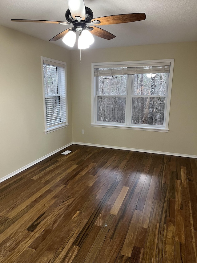 spare room with dark hardwood / wood-style floors and a textured ceiling