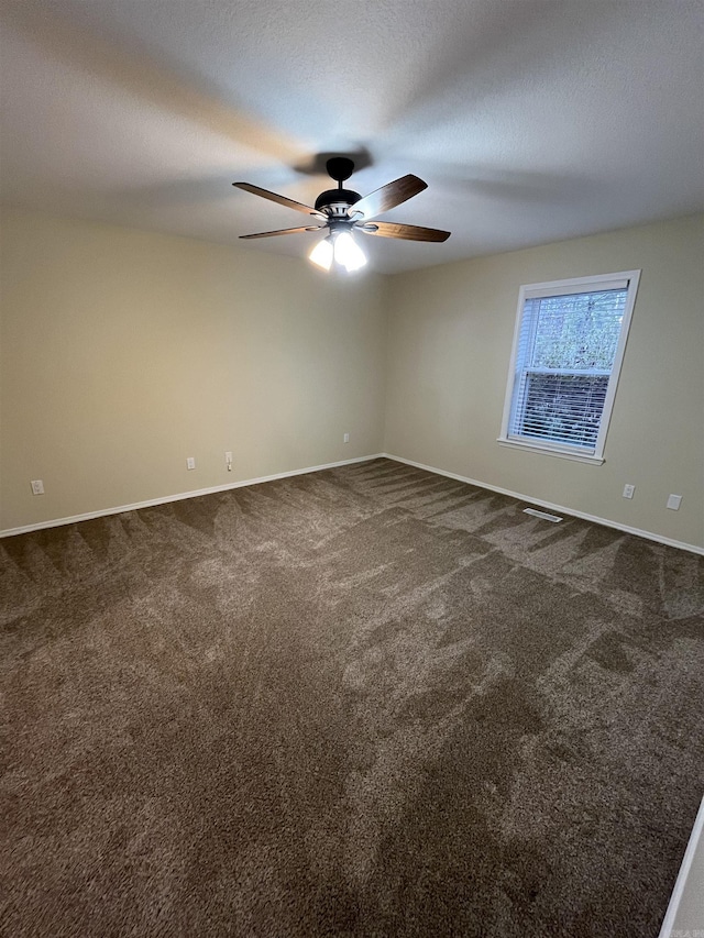 carpeted empty room with ceiling fan and a textured ceiling