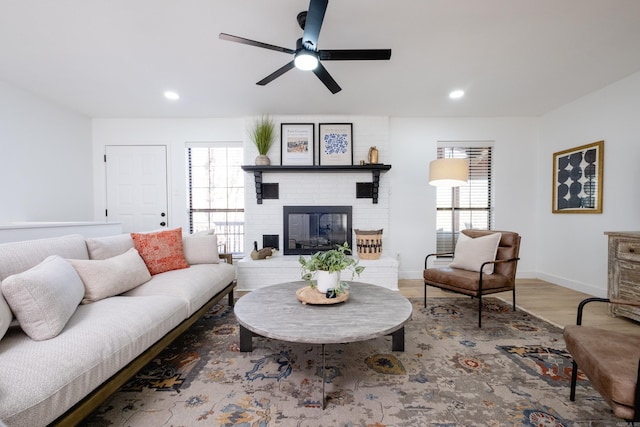 living room with hardwood / wood-style floors, a wealth of natural light, a fireplace, and ceiling fan