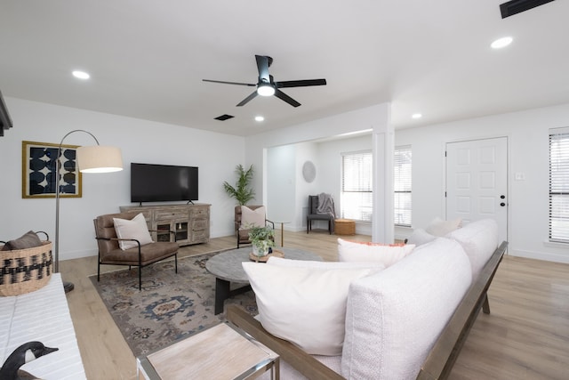 living room with light hardwood / wood-style floors and ceiling fan