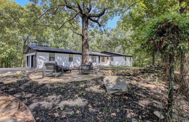 back of house with a garage and a patio area