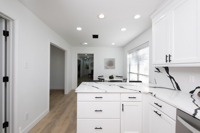 kitchen featuring white cabinetry, light stone countertops, and kitchen peninsula