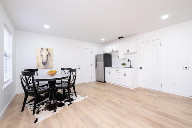 dining room featuring sink and light hardwood / wood-style flooring