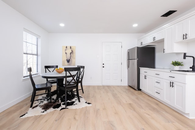 dining area featuring sink and light wood-type flooring