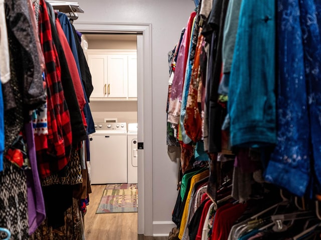 walk in closet featuring independent washer and dryer and light hardwood / wood-style flooring