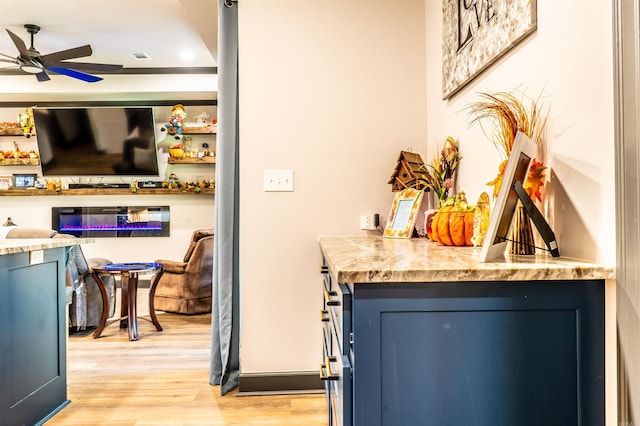 bar with ceiling fan, blue cabinetry, and light wood-type flooring