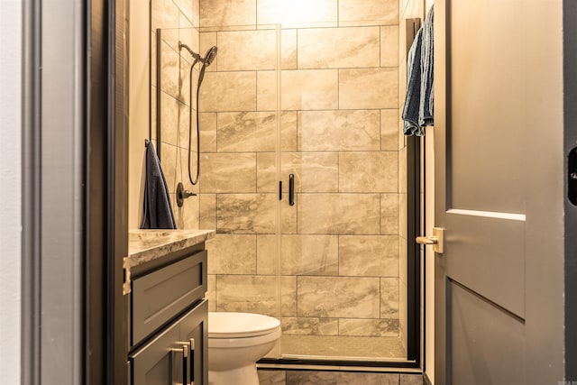 bathroom with walk in shower, vanity, and toilet