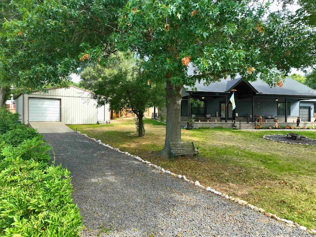 view of front of house featuring an outbuilding, a garage, a front yard, and a porch