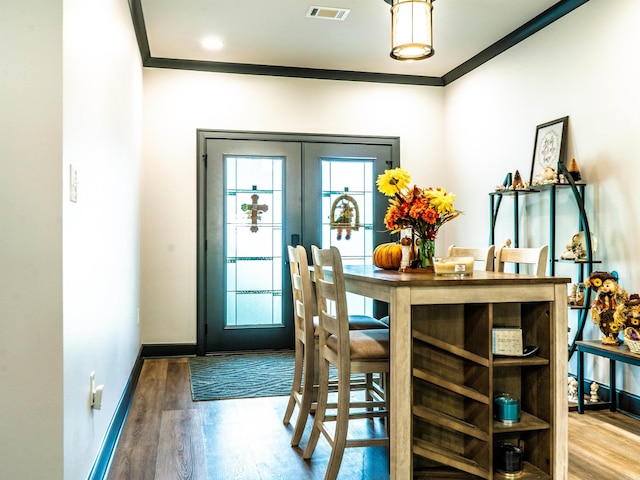 dining area with ornamental molding, hardwood / wood-style floors, and french doors