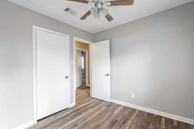 unfurnished bedroom with ceiling fan and hardwood / wood-style floors