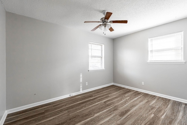 spare room featuring ceiling fan, dark wood-type flooring, and a textured ceiling