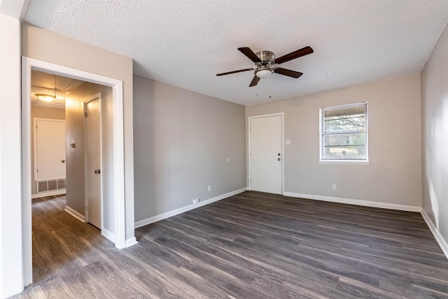 empty room featuring dark hardwood / wood-style flooring and a textured ceiling