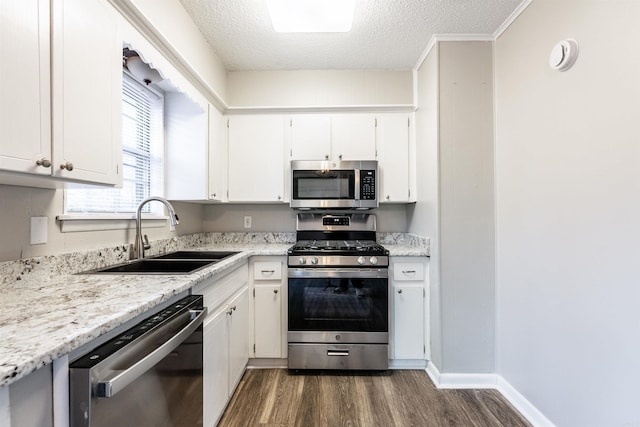 kitchen with dark wood-type flooring, sink, white cabinetry, a textured ceiling, and stainless steel appliances