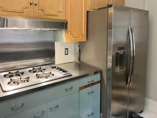 kitchen with white gas stovetop and stainless steel fridge with ice dispenser