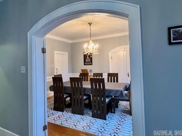 dining room with crown molding and a chandelier