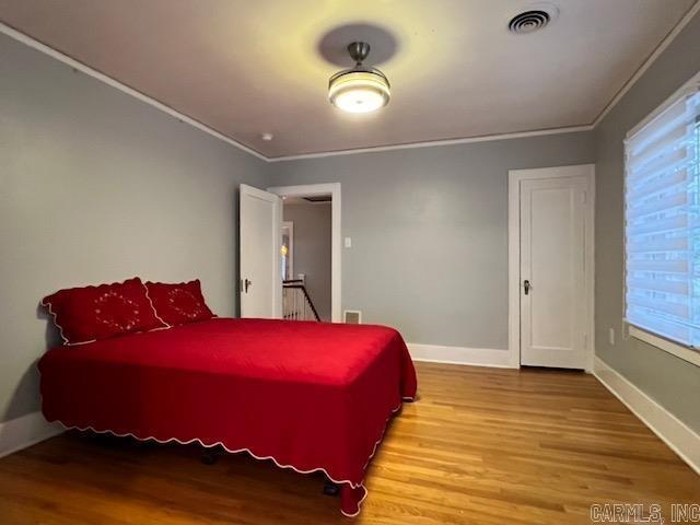 bedroom featuring crown molding and hardwood / wood-style floors