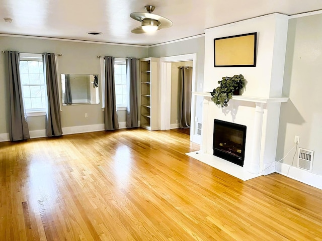 unfurnished living room featuring crown molding, a high end fireplace, and hardwood / wood-style floors