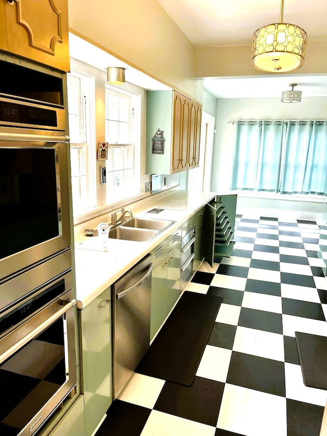 kitchen featuring hanging light fixtures, stainless steel appliances, and sink