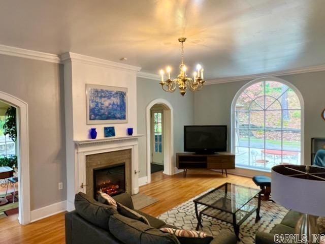 living room featuring hardwood / wood-style flooring, ornamental molding, and a chandelier