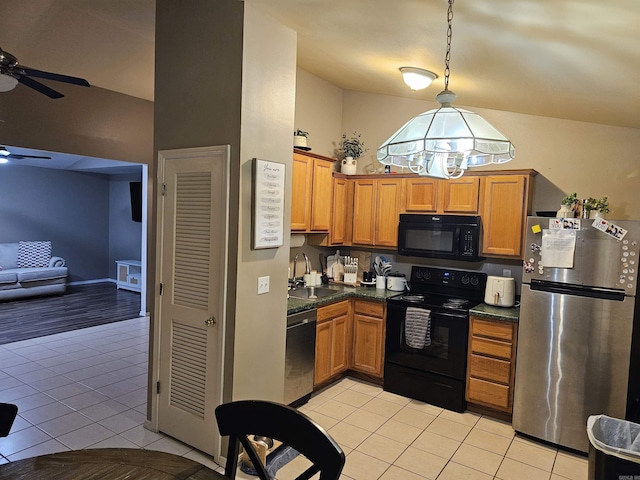 kitchen featuring pendant lighting, sink, light tile patterned floors, and black appliances