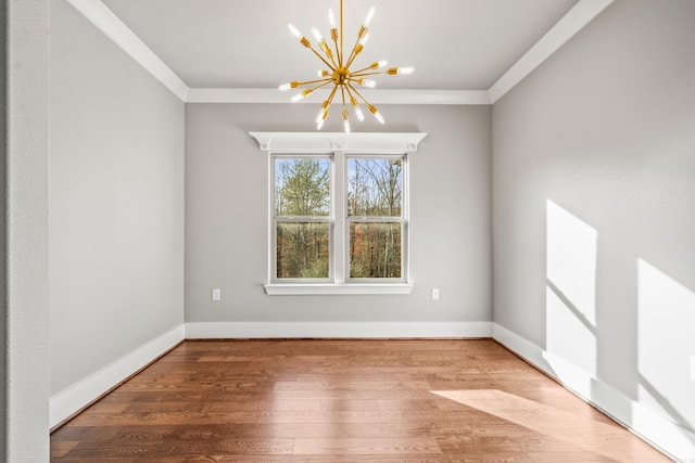 unfurnished room featuring crown molding, hardwood / wood-style floors, and a chandelier