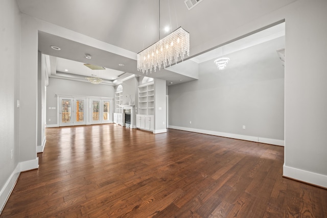 unfurnished living room with hardwood / wood-style floors and built in shelves