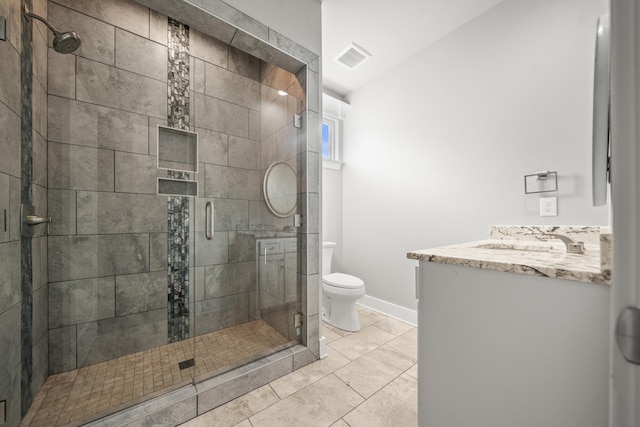 bathroom featuring vanity, tile patterned flooring, a shower with shower door, and toilet