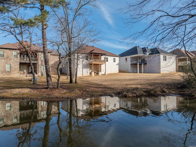 back of house with a balcony and a water view