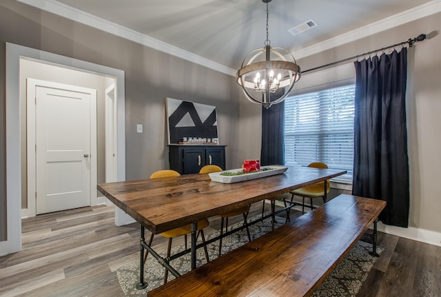 dining room with crown molding, light hardwood / wood-style flooring, and a chandelier