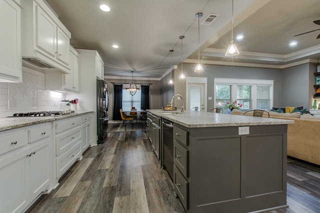 kitchen with hanging light fixtures, white cabinetry, black refrigerator, and a spacious island